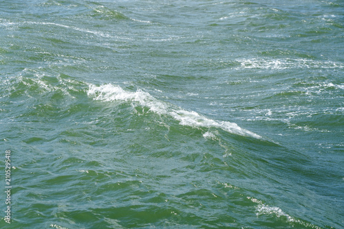Картината върху платно Close-up view of turbulent emerald green sea water surface.
