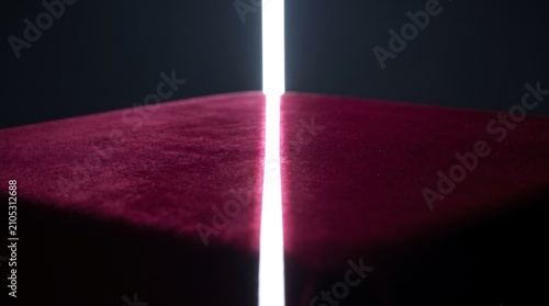 Burgundy Velvet Fabric Surface Bisected by a Vertical Beam of Bright White Light in a Minimalist Artistic Studio Setting