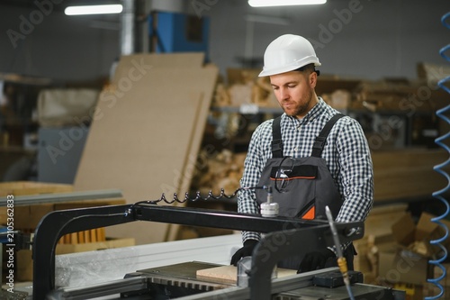 Foto Skilled worker operating cnc machine in furniture production