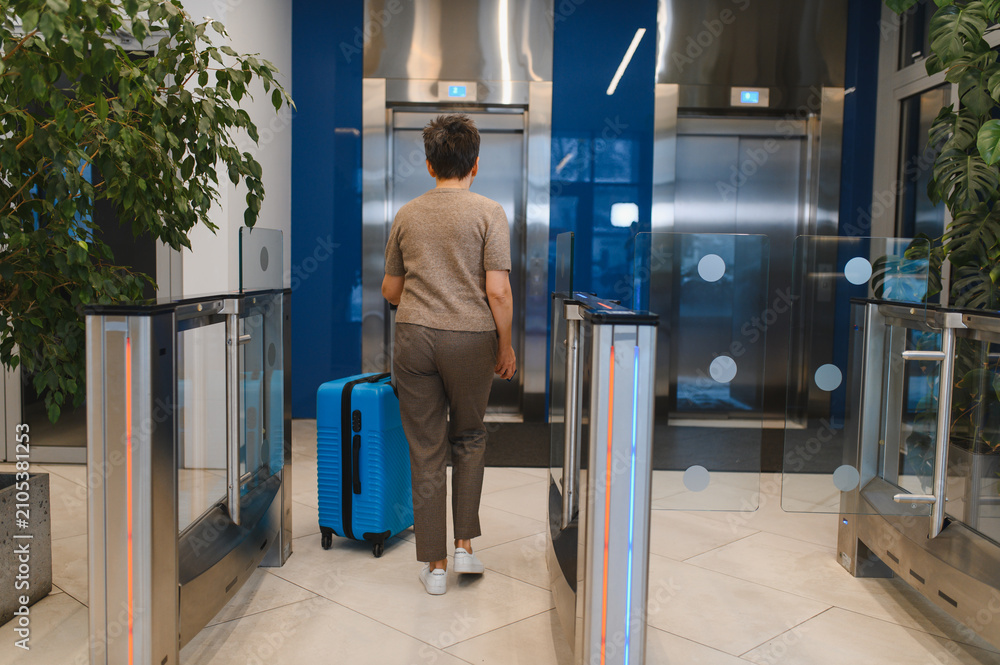 Obraz premium Woman traveler passing turnstile gate with luggage