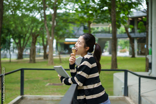 Foto University student, young woman college student eating ice cream standing in cam