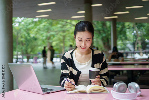 Education, university and woman in campus, research and books for school project or exam. Laptop, notebook and internet, college student studying with technology and e learning on campus