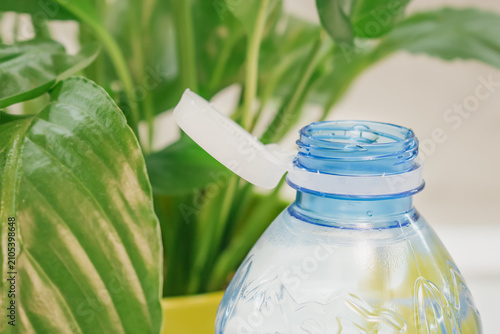 Canvas Print Macro view of an open clear blue plastic bottle showing attached white tethered