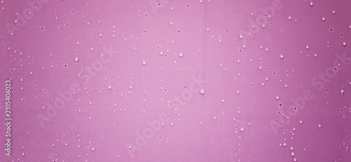 Water droplets on pink surface create a colorful and simple design