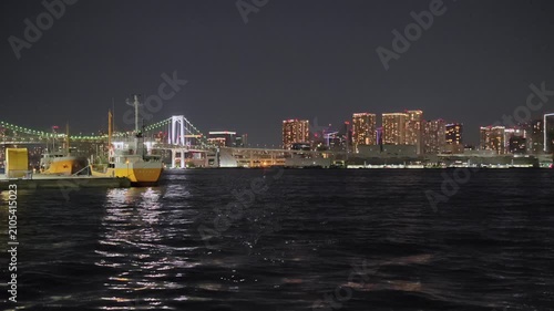 橋と船と高層ビルが見える港の夜景。