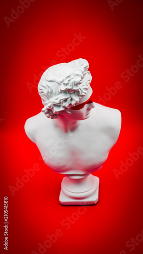 Contemporary Classical White Greek Bust with Red Painted Eyes on a Vibrant Red Background