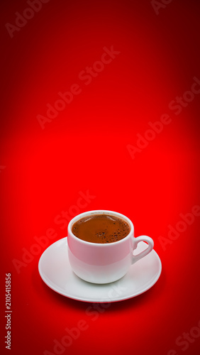 Traditional Turkish Coffee in a White Cup Isolated on a Vibrant Red Background 