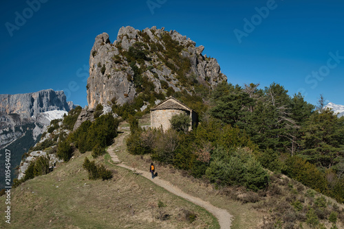 A young girl hiking up to the Chapel of San Juan and San Pablo in Tella, Huesca, located in the Aragonese Pyrenees.