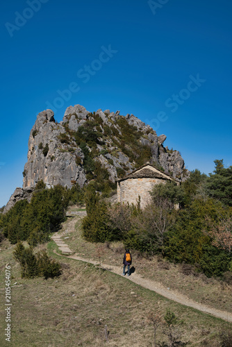 A young girl hiking up to the Chapel of San Juan and San Pablo in Tella, Huesca, located in the Aragonese Pyrenees.