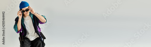 Canvas Print A young college student dons a fashionable bomber jacket and sunglasses, posing