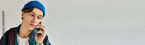 Konstfotografi A young college student in a trendy bomber jacket engages in a phone call in a sleek studio