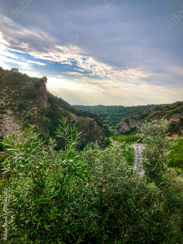 Cuadro en lienzo Scenic Green Mountain Valley with Sun Rays Under Dramatic Cloudy Sky
A scenic view of a lush green mountain valley illuminated by sun rays breaking through dramatic clouds
