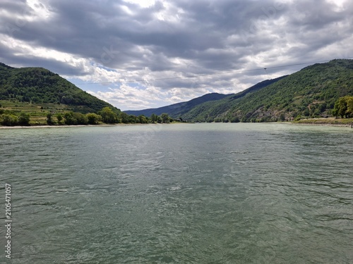 Donau in der Wachau an einem sonnig und wolkigen Tag, Wachautourismus, von der Rollfähre aus gesehen mit Weinbergen