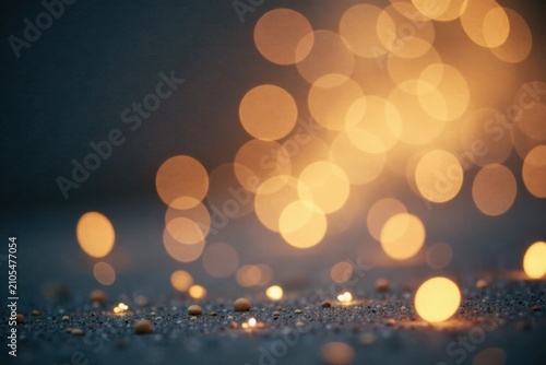 Abstract Dark Background with Warm Golden Bokeh Lights and Small Pebbles on Ground