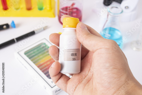 Konstfotografi Hand Holding Chemical Reagent Bottle in Laboratory Workspace