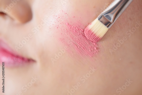 Applying lipstick with makeup brush close-up