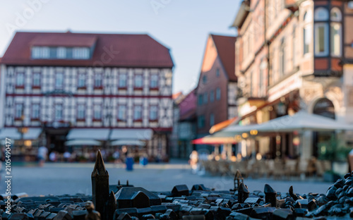 Photos Bronze tactile city model in the foreground with blurred historic half-timbered buildings of Wernigerode town square in bokeh background