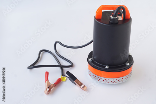 Portable DC submersible water pump with battery clips isolated on a white background. Electric water transfer pump for irrigation, drainage, agriculture, emergency water removal, and industrial applic
