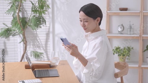 スマホと通帳を見る女性