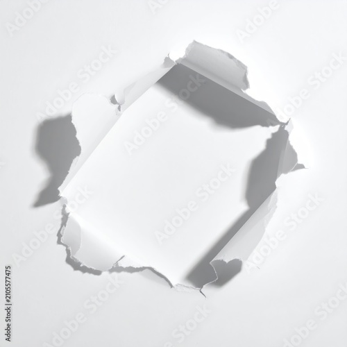 White paper torn to reveal a bright white square aperture with shadows
