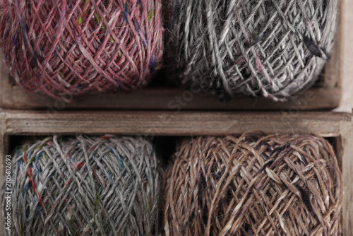 Photos Four skeins of tweed yarn lie in a wooden box