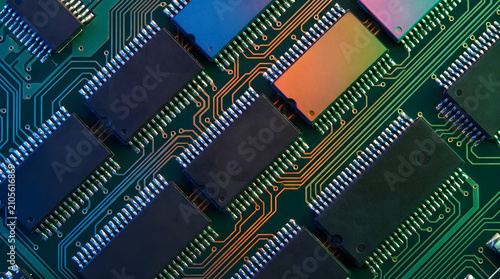 Close-up of multiple integrated circuits densely arranged on a green printed circuit board