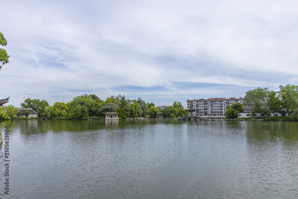 Fototapeta premium Tranquil urban lake with Chinese pavilion and bridge in spring