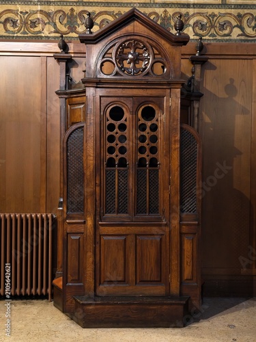 Antiguo confesionario de madera en el interior de una iglesia católica