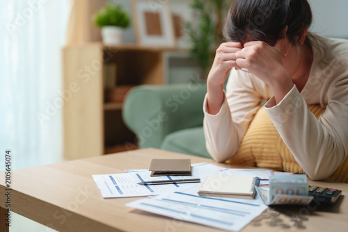 Canvastavla Stressed woman reviewing bills and financial documents at home, feeling worried about debt and monthly expenses