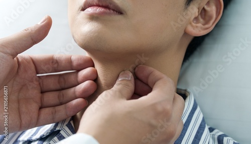 Palpating doctor checking teen patient reclining on clinic bed, striped shirt and examiner hands