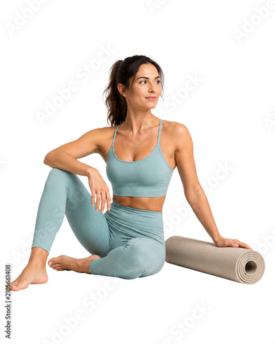 Woman in yoga attire sitting next to a rolled yoga mat, isolated on transparent background