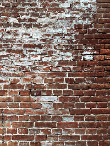 Old red brick wall texture with white peeling paint background.