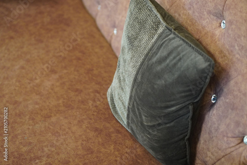 top view closeup green pillow layered placed on a brown leather sofa, object, decor, fashion, old, antique, copy space