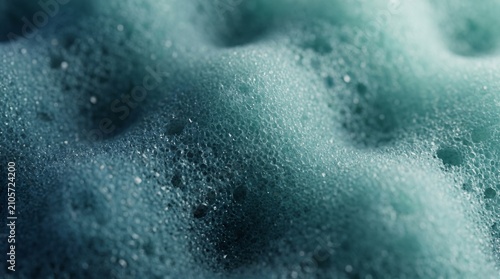 Macro photography of a teal blue cleaning sponge showing highly detailed porous texture.
