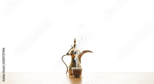 Authentic Golden Arabic Dallah Coffee Pot with Steaming Cup of Gahwa