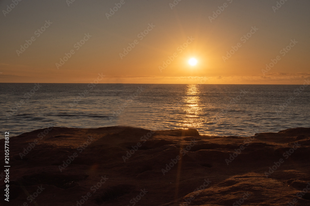 Obraz premium Sunrise Over Atlantic Ocean with Golden Light and Calm Sea