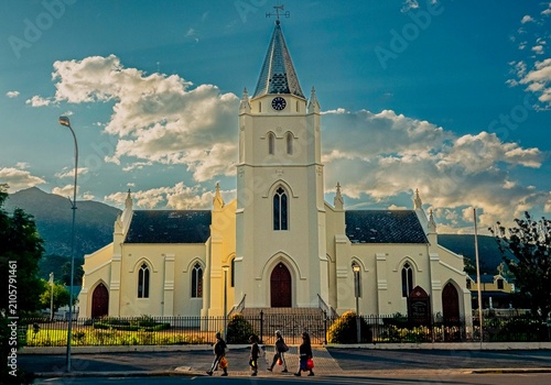 Billede på lærred Workers pass in front of the imposing Dutch Reformed church, Montagu in the late afternoon light