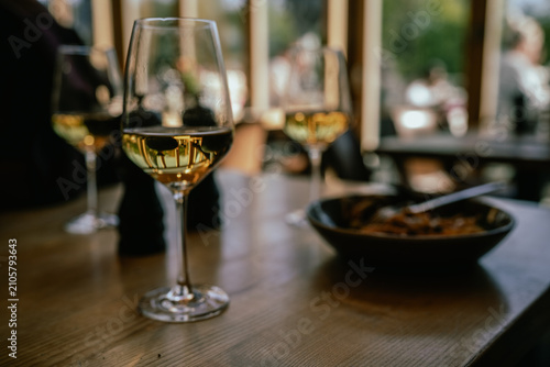 The photo shows a lunch served at a café with a glass of wine on the table. Indoor restaurant setting, plated meal, dining table, natural light, close-up view, European dining atmosphere.