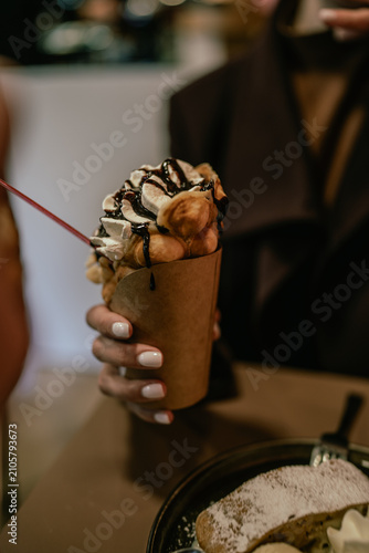 The photo shows ice cream served in a soft waffle cone. Frozen dessert with a creamy texture, close-up view, outdoor setting, natural light, sweet food, summer season, ready to eat.