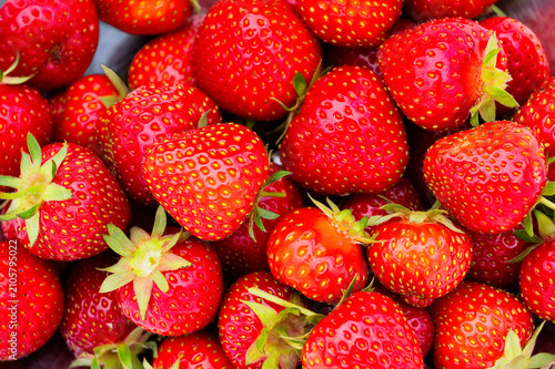 A heap of freshly picked organic strawberries in a bowl. 