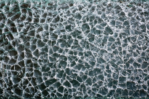 Close-up of shattered glass, fractured into a complex web of sharp fragments