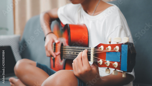 Фотография Person playing colorful acoustic guitar sitting comfortably in modern living roo