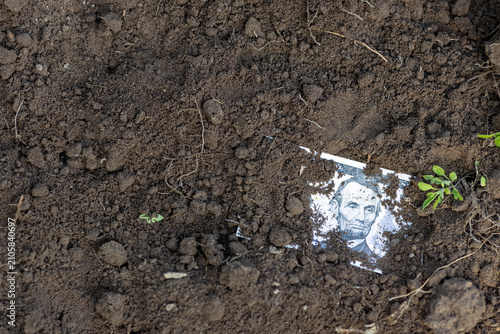 Buried Five-Dollar Bill Symbol of Devalued Money