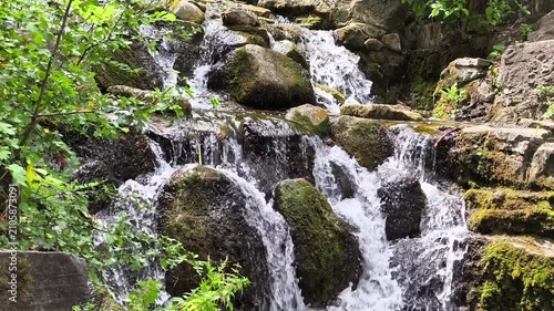 Small Artificial Rocky Waterfall with Mossy Stones in a Garden