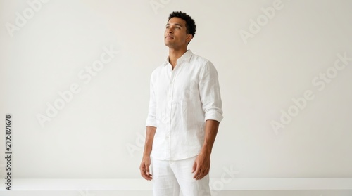 A vibrant young man in elegant attire showcasing confidence and charm in a minimalist space.