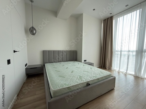 Modern Minimalist Bedroom Interior with Upholstered Bed and Large Window