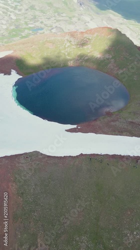 Vertical Video of Scenic Volcanic Crater Pond with Turquoise Water and Patchy Snow