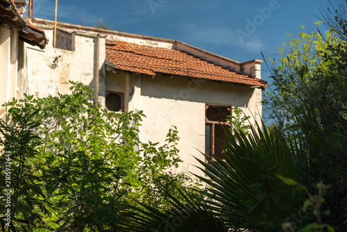 Fotografie An abandoned overgrown hotel braided with beautiful flowering plants