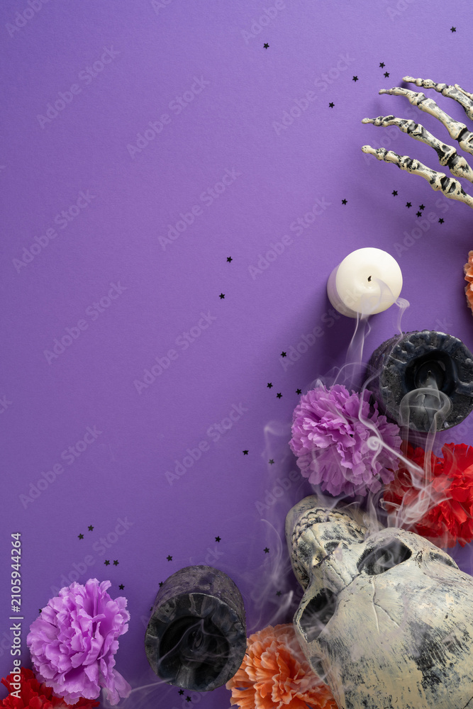 Fototapeta premium Dia de los Muertos altar with skulls, candles, marigolds and smoky purple vertical background