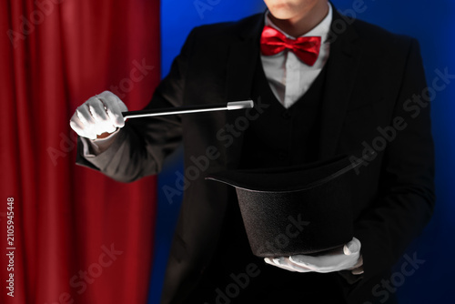Foto Magician showing trick with wand and top hat on stage, closeup